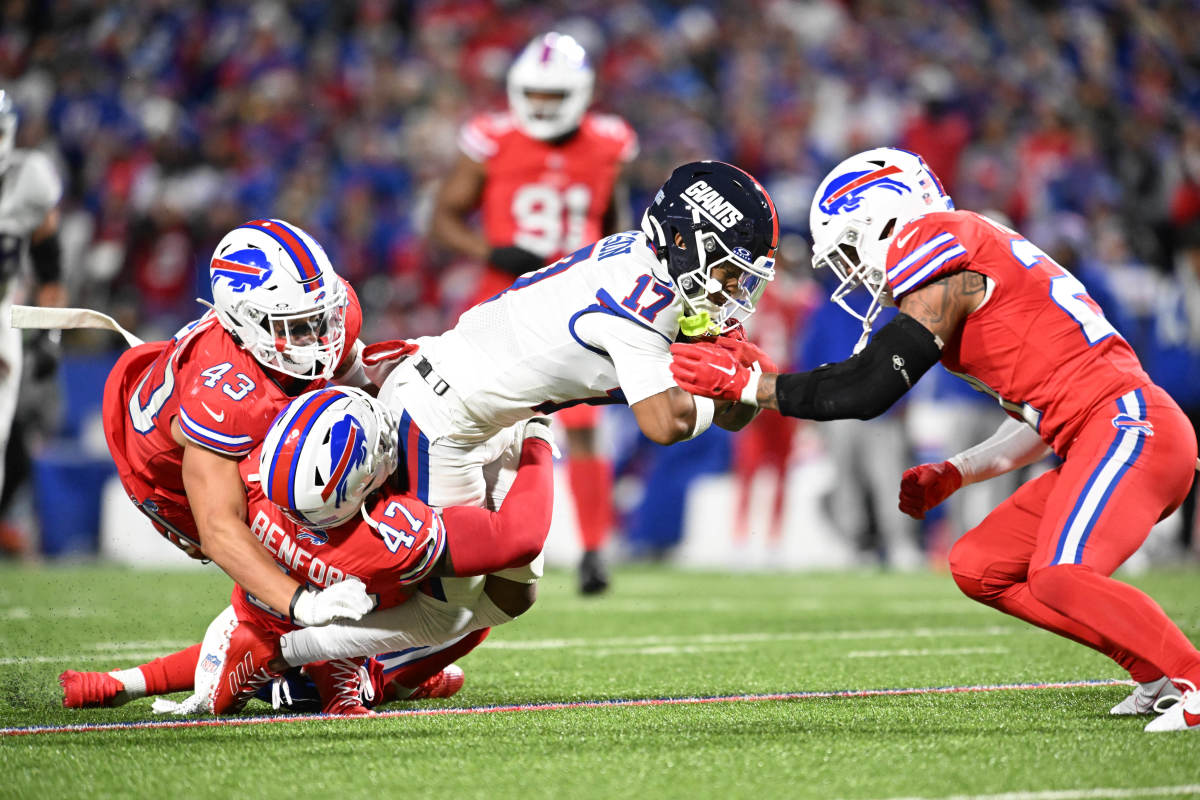 New York Giants wide receiver Wan'Dale Robinson (17) is tackled by Buffalo Bills cornerback Christian Benford (47) and linebacker Terrel Bernard (43) and safety Jordan Poyer (21)